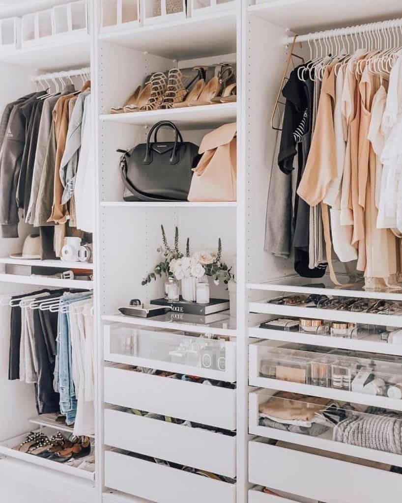 Neatly organized closet with clothes on hangers, shoes, handbags, and accessories on shelves, and makeup in transparent drawers