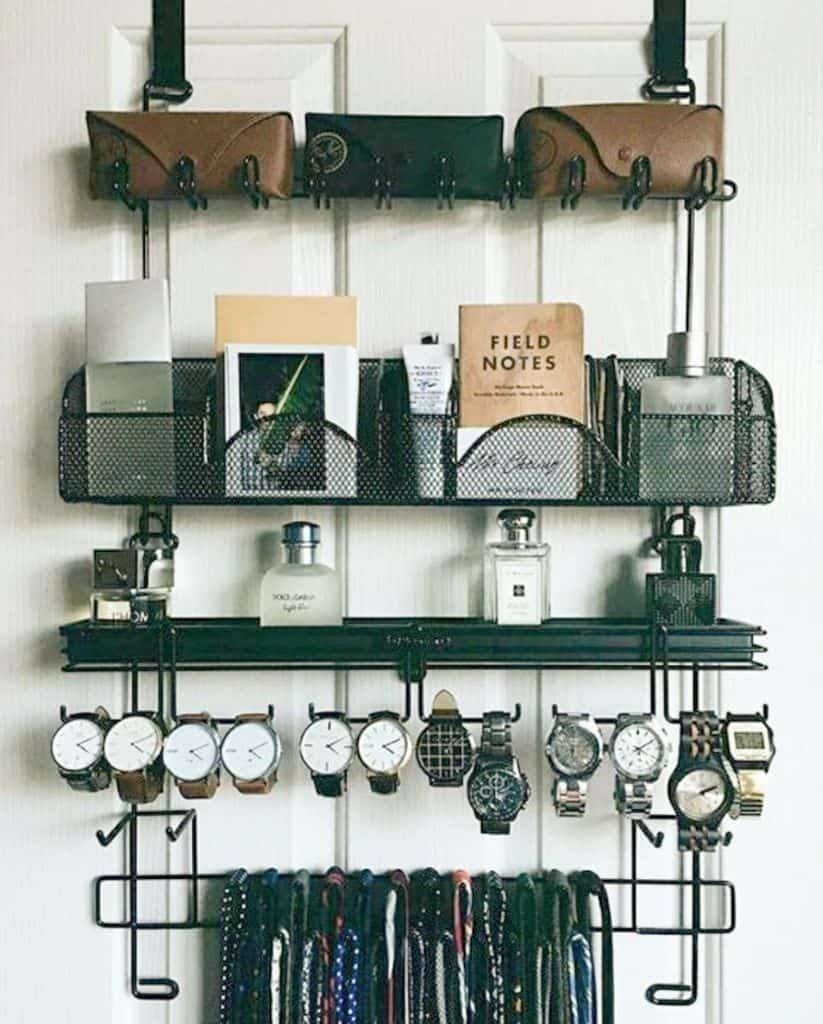 Wall organizer with sunglasses, notebooks, perfume bottles, watches, and ties neatly arranged on shelves and hooks