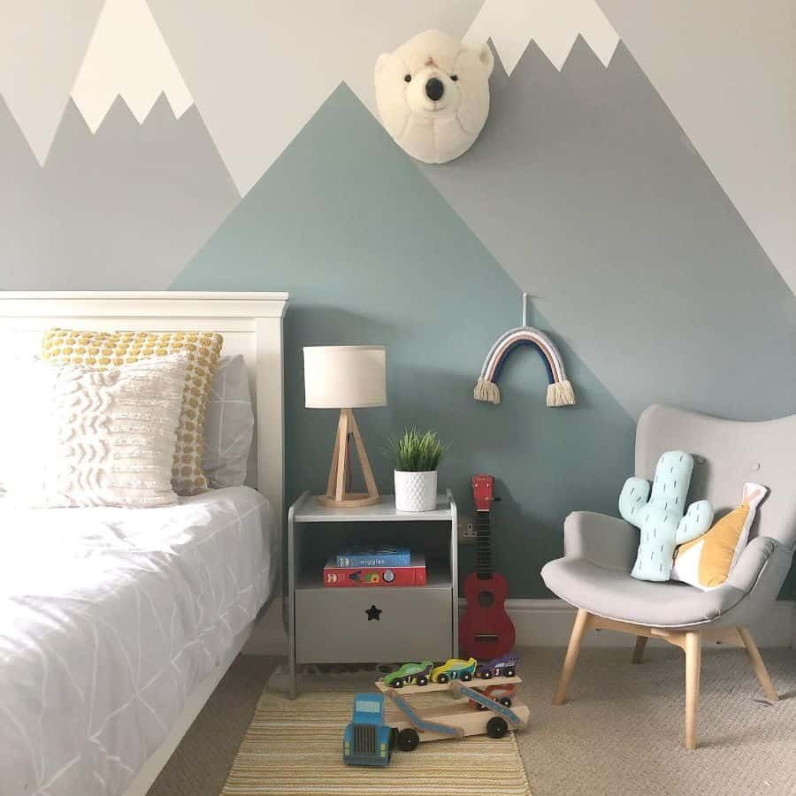 Modern kids' room with a mountain mural, plush polar bear wall decor, cozy bed, reading nook, and playful accents in soft colors