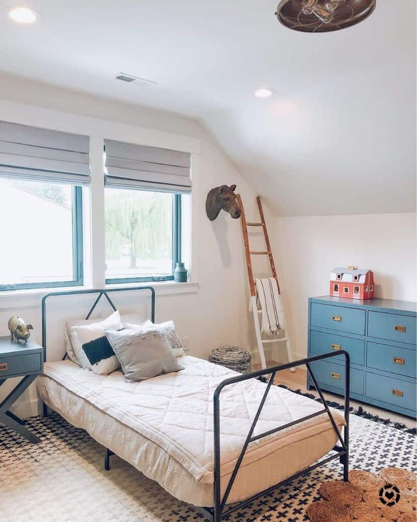 Rustic kids' bedroom with a metal bed frame, blue dresser, horse wall decor, wooden ladder, and cozy neutral tones