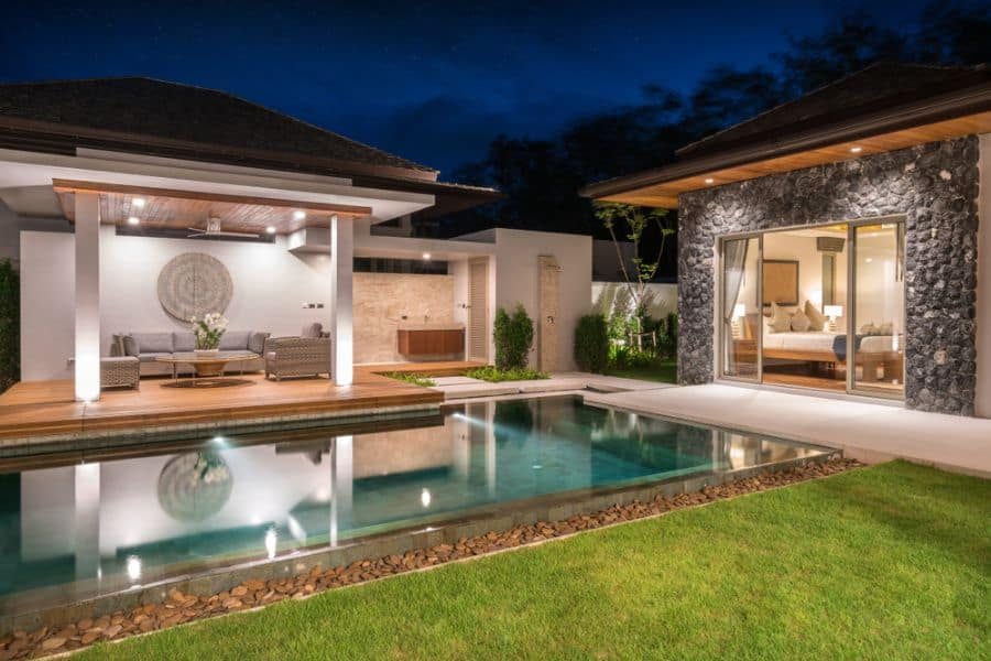 Luxurious modern poolside cabana with warm lighting, sleek outdoor seating, and a serene infinity pool, creating a relaxing retreat