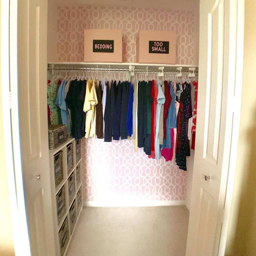 Organized closet with clothes hanging neatly on a rod, signs above read "Bedding" and "Too Small," open shelving on the left side