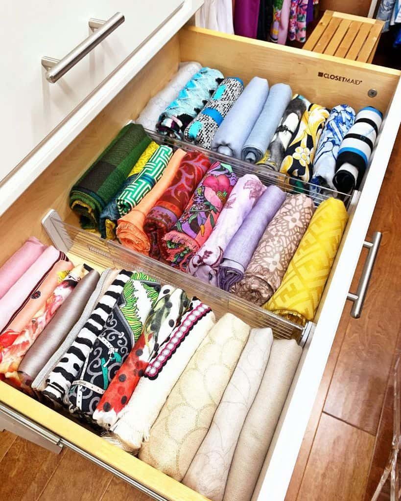 Drawer neatly organized with colorful, folded fabrics in rows, showcasing a variety of patterns and textures