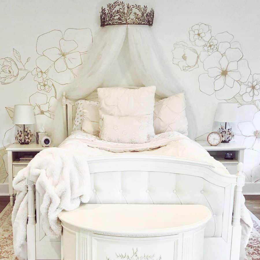 Elegant girls' bedroom with a tufted white bed, floral wall mural, sheer canopy with crown detail, and soft neutral decor