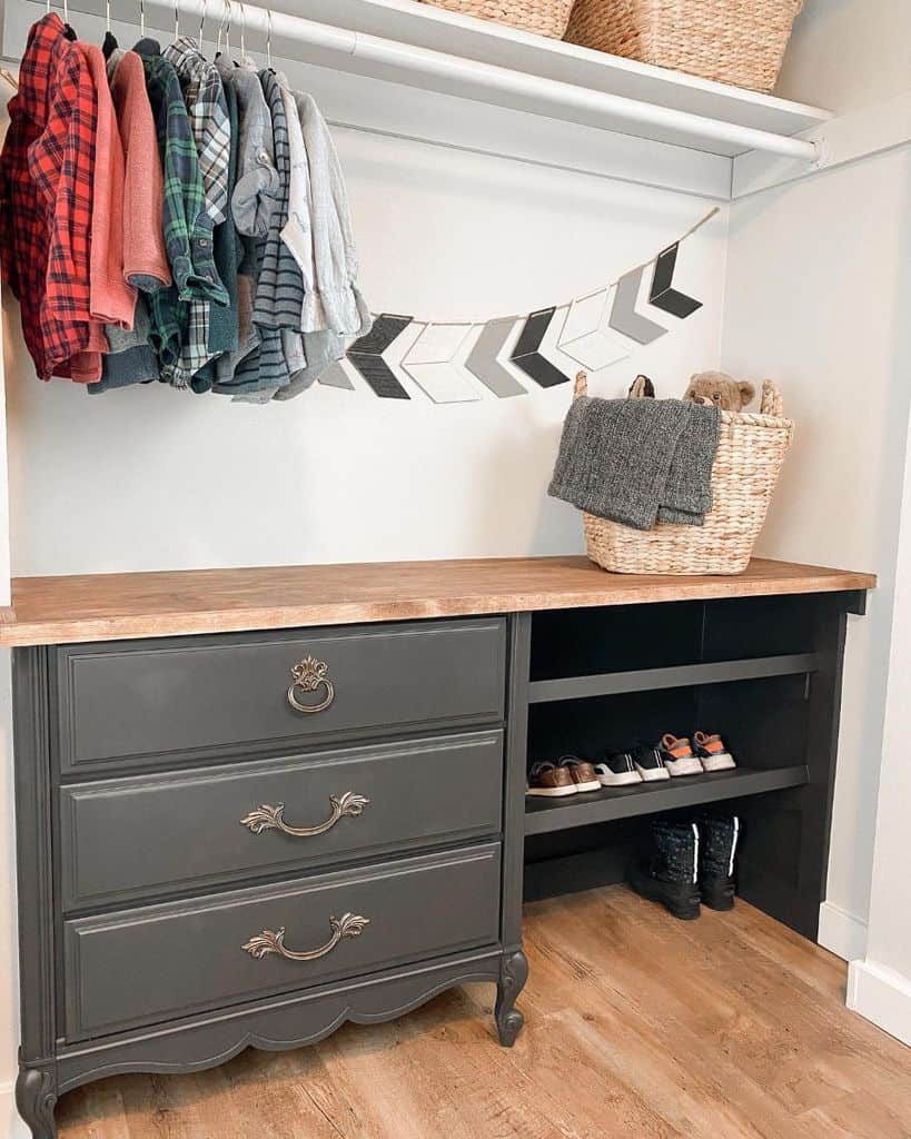 Closet with hanging plaid shirts, dresser, baskets, folded clothes, shoes, and decorative arrows on the wall