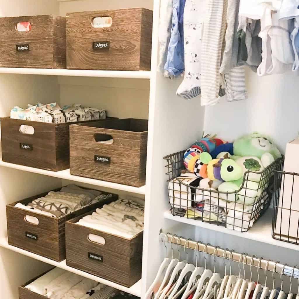 Organized closet with labeled wooden boxes, wire baskets holding toys, and clothes hanging neatly on racks