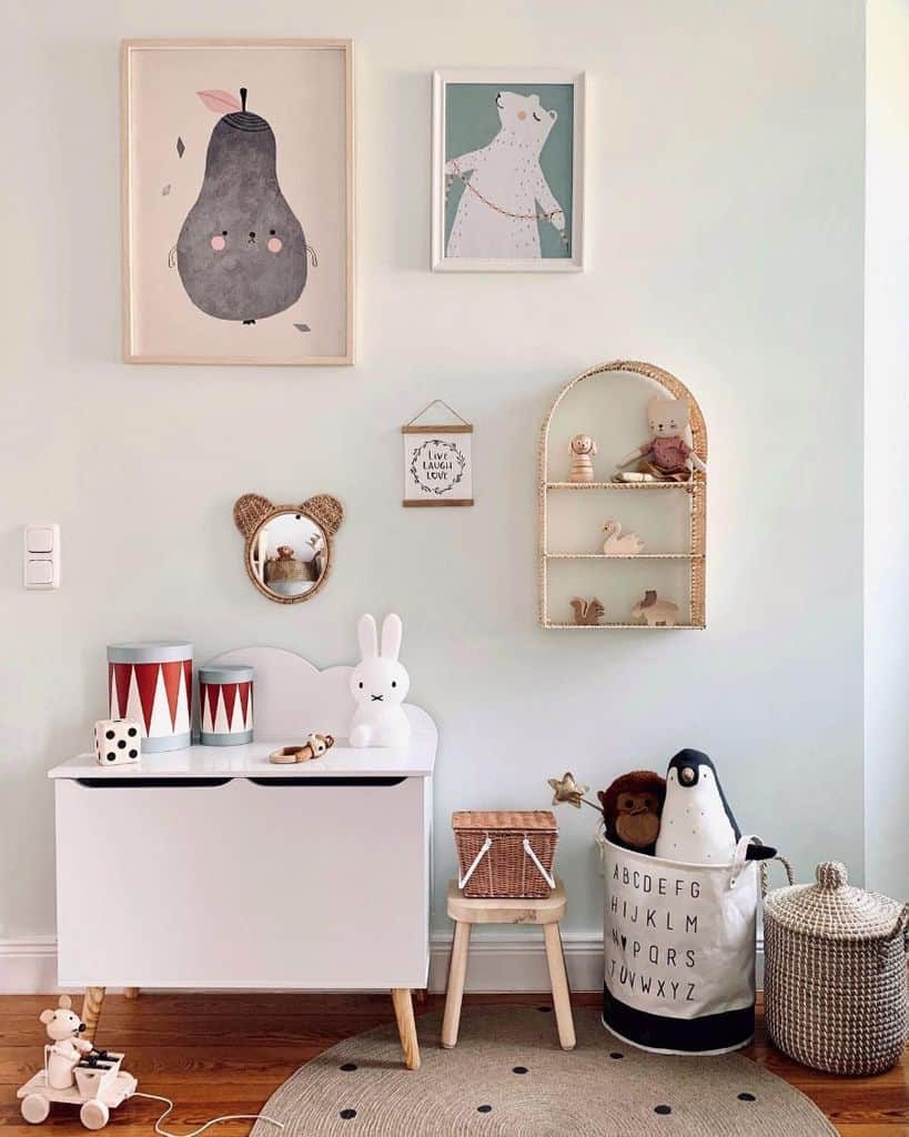 Charming kids' room with playful wall art, a white toy chest, wicker storage, soft pastel decor, and cute stuffed animals