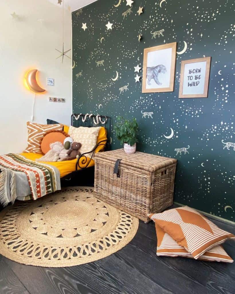 Cozy kids' bedroom with a celestial-themed dark green wallpaper featuring stars, moons, and tigers, complemented by a warm-toned bed, a glowing crescent moon light, and natural woven decor