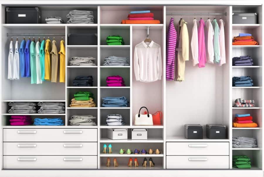 Neatly organized closet with colorful clothes on hangers, folded garments on shelves, and shoes below, four drawers and two handbags visible