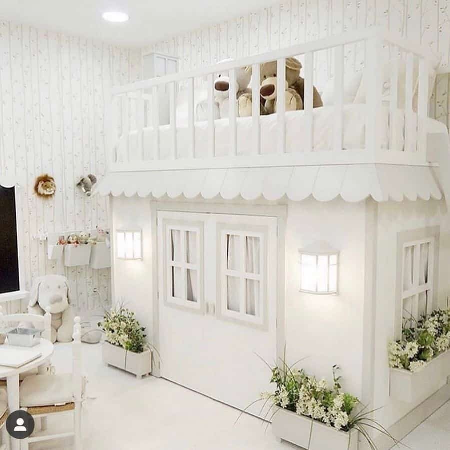 Elegant all-white kids' bedroom featuring a custom-built loft bed designed like a miniature house, complete with windows, doors, and a scalloped awning