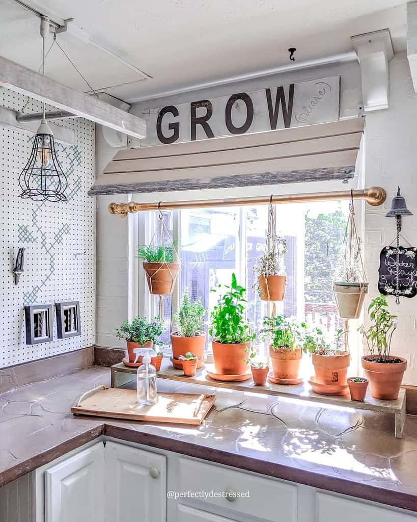 Rustic kitchen herb garden with potted and hanging plants by a sunny window, featuring a 'GROW' sign and cozy farmhouse decor