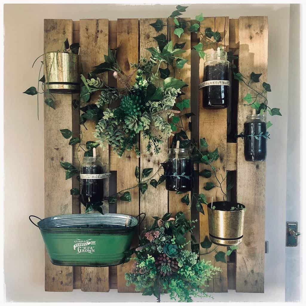 Rustic vertical herb garden made from a wooden pallet, featuring mason jar planters, metal pots, and cascading greenery for a cozy look