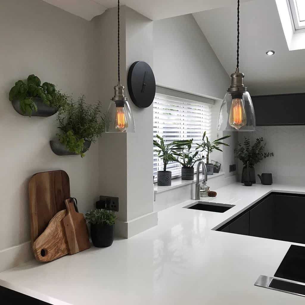 Modern kitchen with a sleek white countertop, wall-mounted herb garden, and hanging glass pendant lights adding warmth and greenery