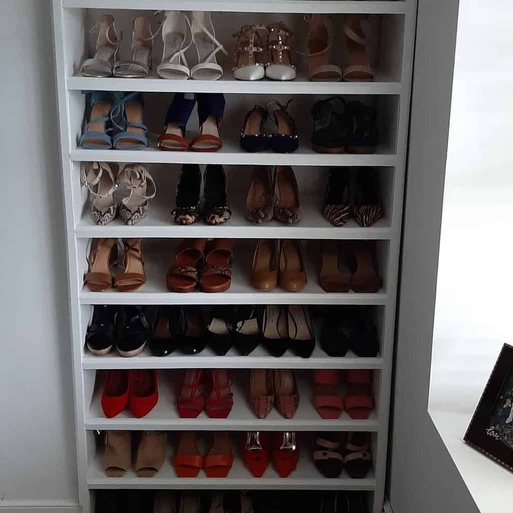 A tall white shoe rack filled with various high-heeled shoes in different colors and styles