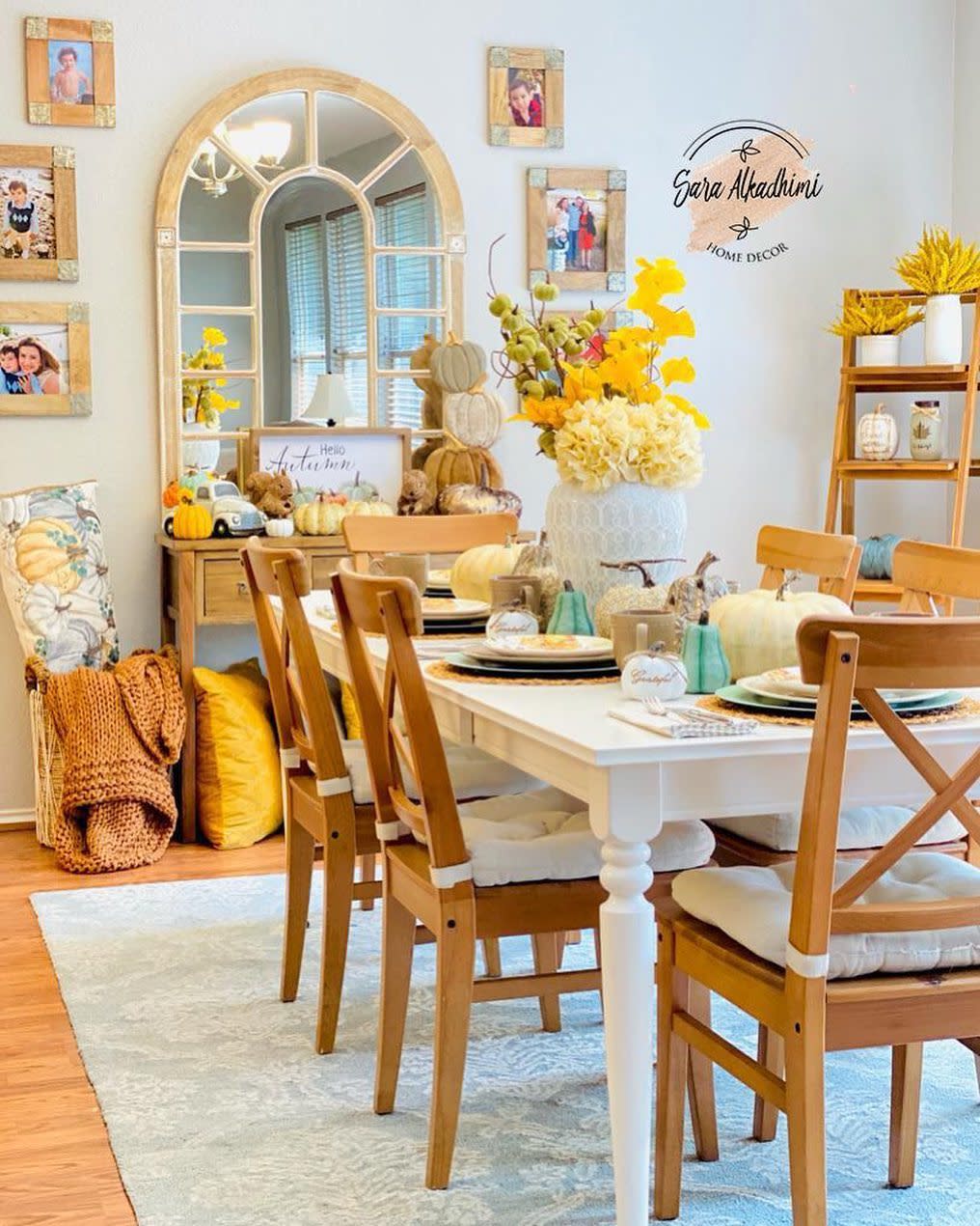 Cozy dining room with a white table and chairs, decorated with fall-themed decor