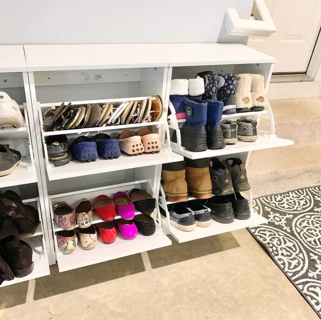 White shoe rack with various shoes: sandals, boots, sneakers, and slippers; gray patterned rug on the floor