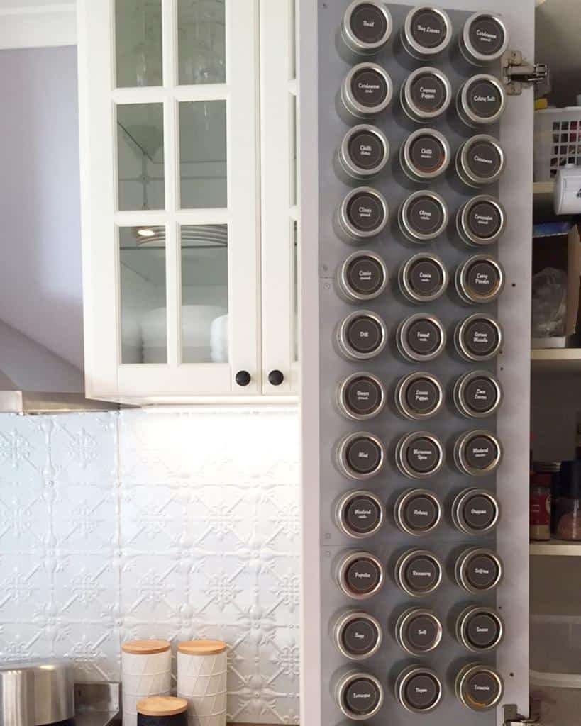 Magnetic spice jars arranged neatly on the inside of a kitchen cabinet door