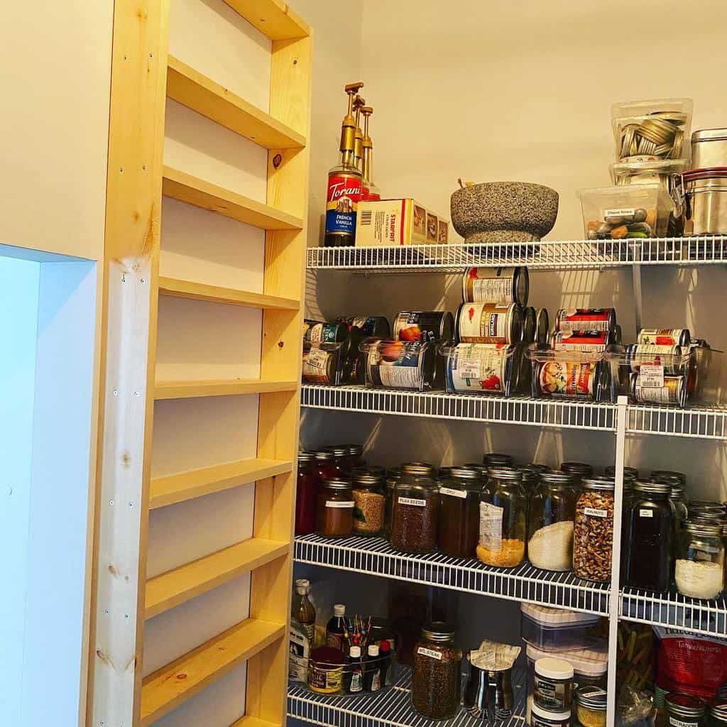 Pantry with wire shelves holding jars, cans, and containers; wooden ladder is leaning against the wall on the left