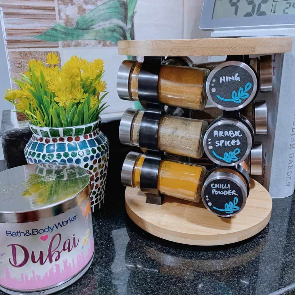 Rotating wooden spice rack with labeled glass jars, adding convenience and style to a well-organized kitchen countertop