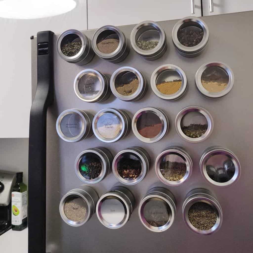 Magnetic spice jars neatly arranged on a refrigerator door, providing a space-saving and modern solution for kitchen organization