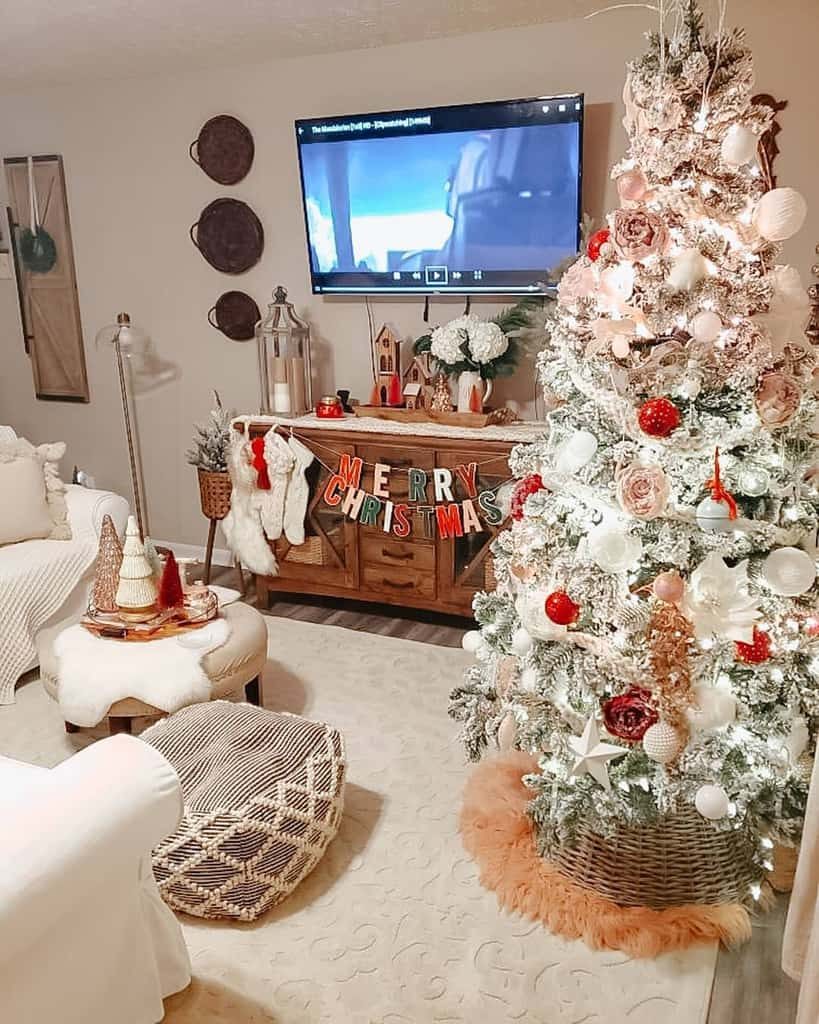 Cozy living room with a decorated Christmas tree, a "Merry Christmas" banner on a cabinet, and a TV displaying a movie