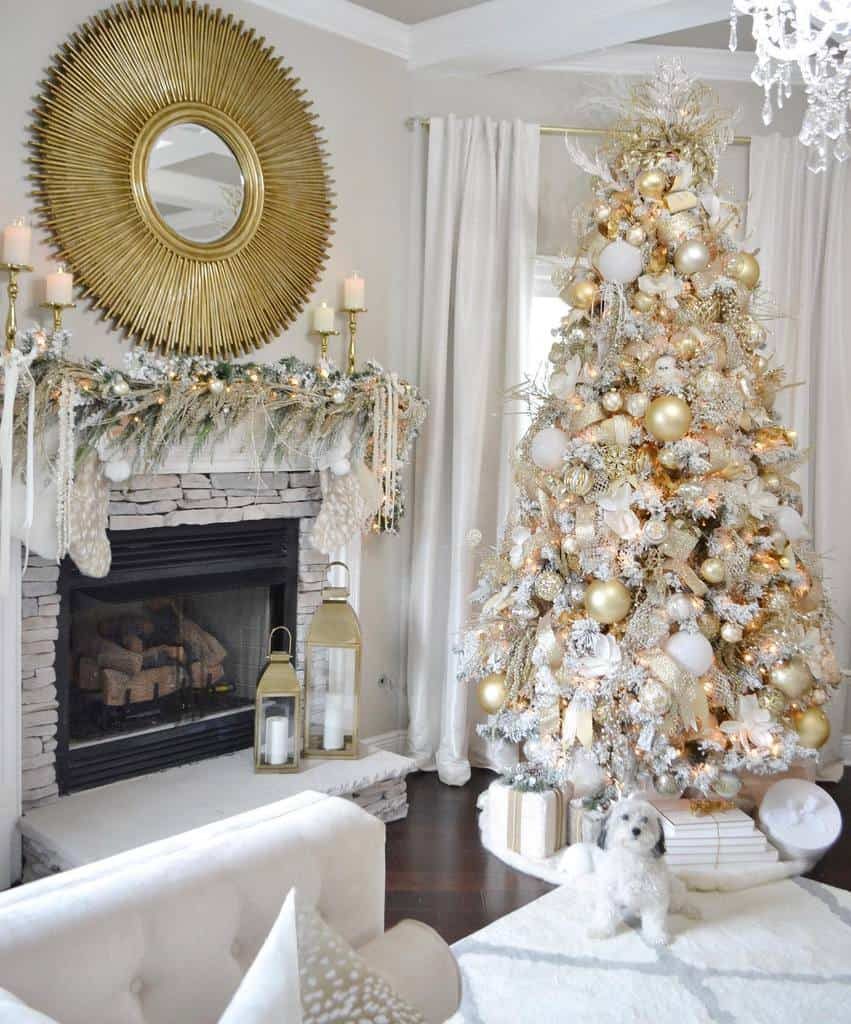 Elegant living room with a white and gold Christmas tree, decorated fireplace, sunburst mirror, and a small dog on the rug