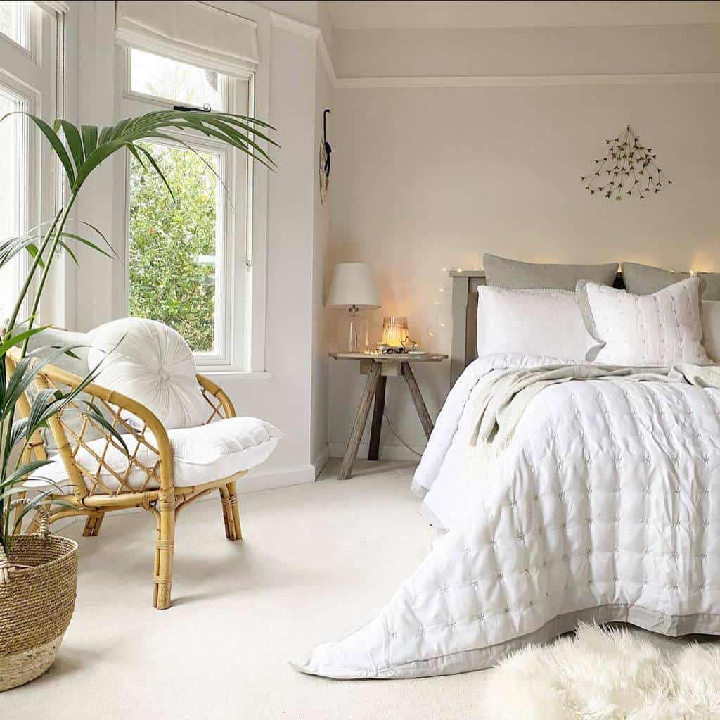 Bright and airy bedroom with a bay window, rattan chair, and soft neutrals, creating a peaceful and inviting retreat.