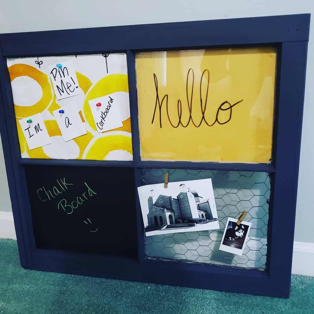 Repurposed old window frame turned into a multifunctional board with sections for corkboard, chalkboard, dry-erase, and photo display.