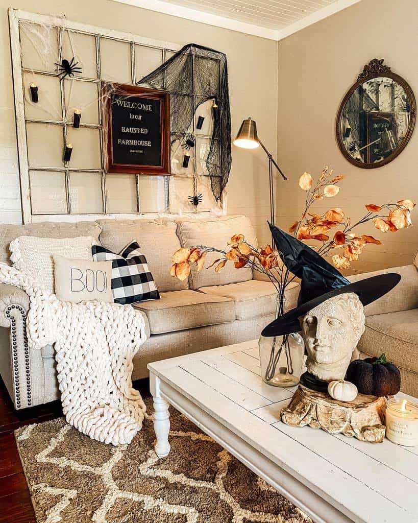 Repurposed old window used as a Halloween wall display with cobwebs, spiders, and candles, complementing a cozy farmhouse living room.