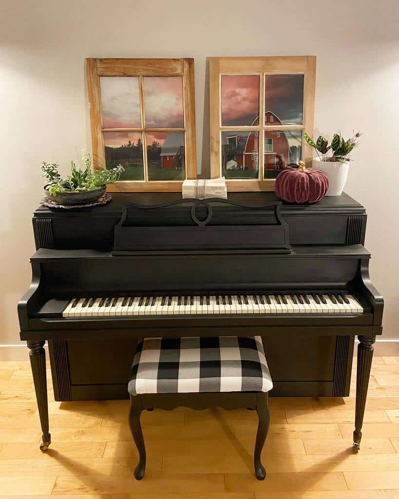 Repurposed old window frames used as farmhouse-style art, featuring scenic barn prints, displayed on a black piano with rustic decor.