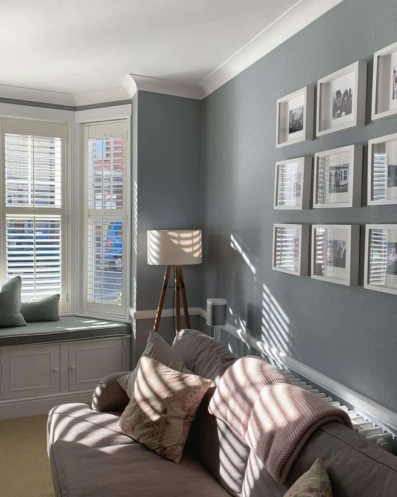 Stylish living room with a bay window, white plantation shutters, a built-in bench, and soft neutral tones, creating a cozy and elegant space.