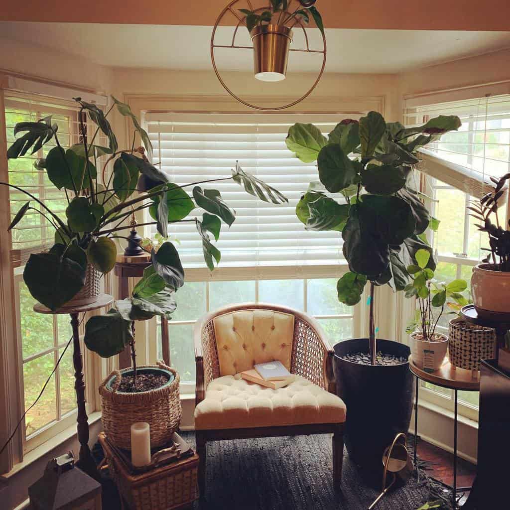 Lush bay window reading nook with abundant greenery, a tufted vintage chair, and soft natural light, creating a tranquil and cozy retreat.