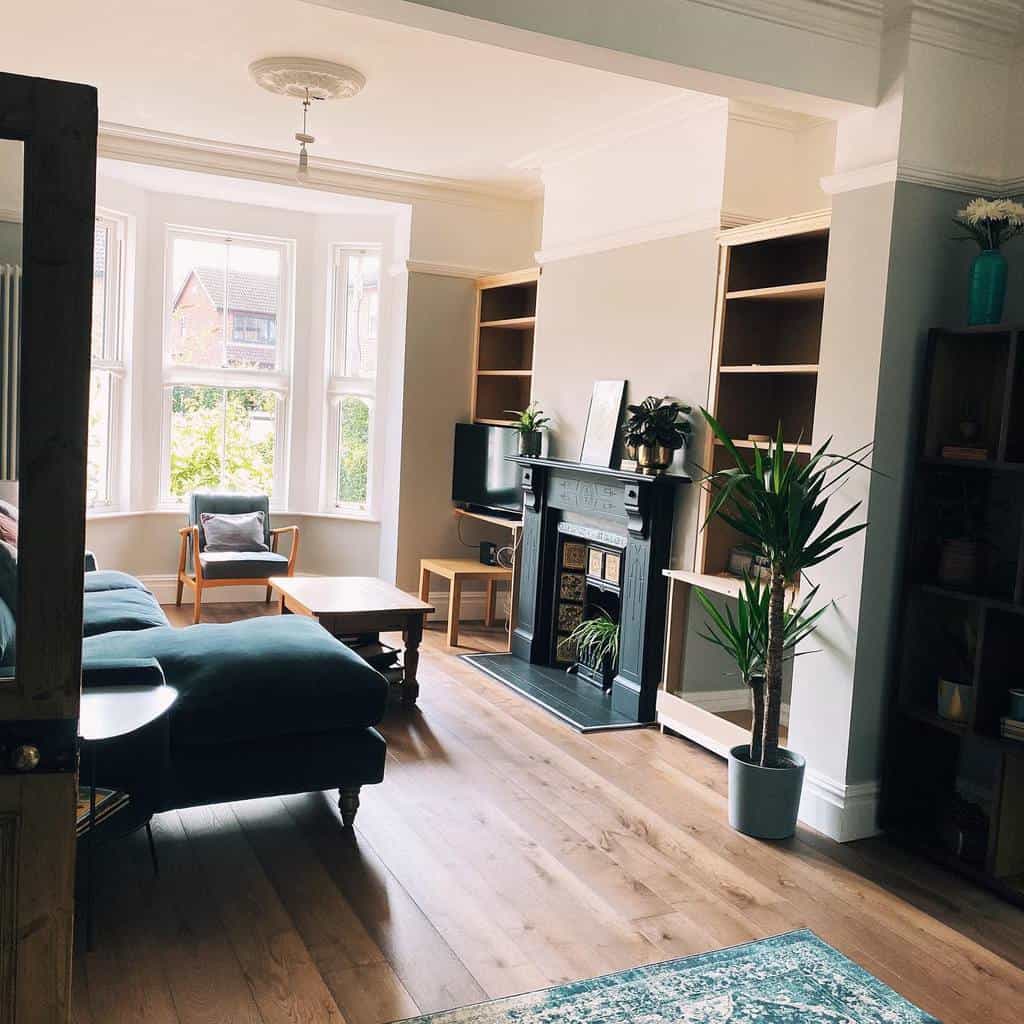 Bright and airy living room with a bay window, cozy seating, a fireplace, and modern decor, creating a stylish and inviting space.