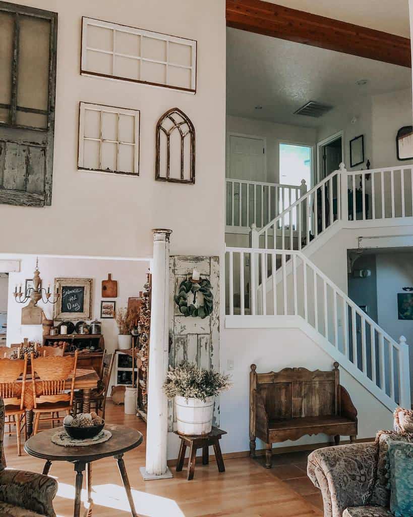 Vintage farmhouse-style living space with repurposed old window frames arranged as wall decor, rustic wood furniture, and cozy accents.