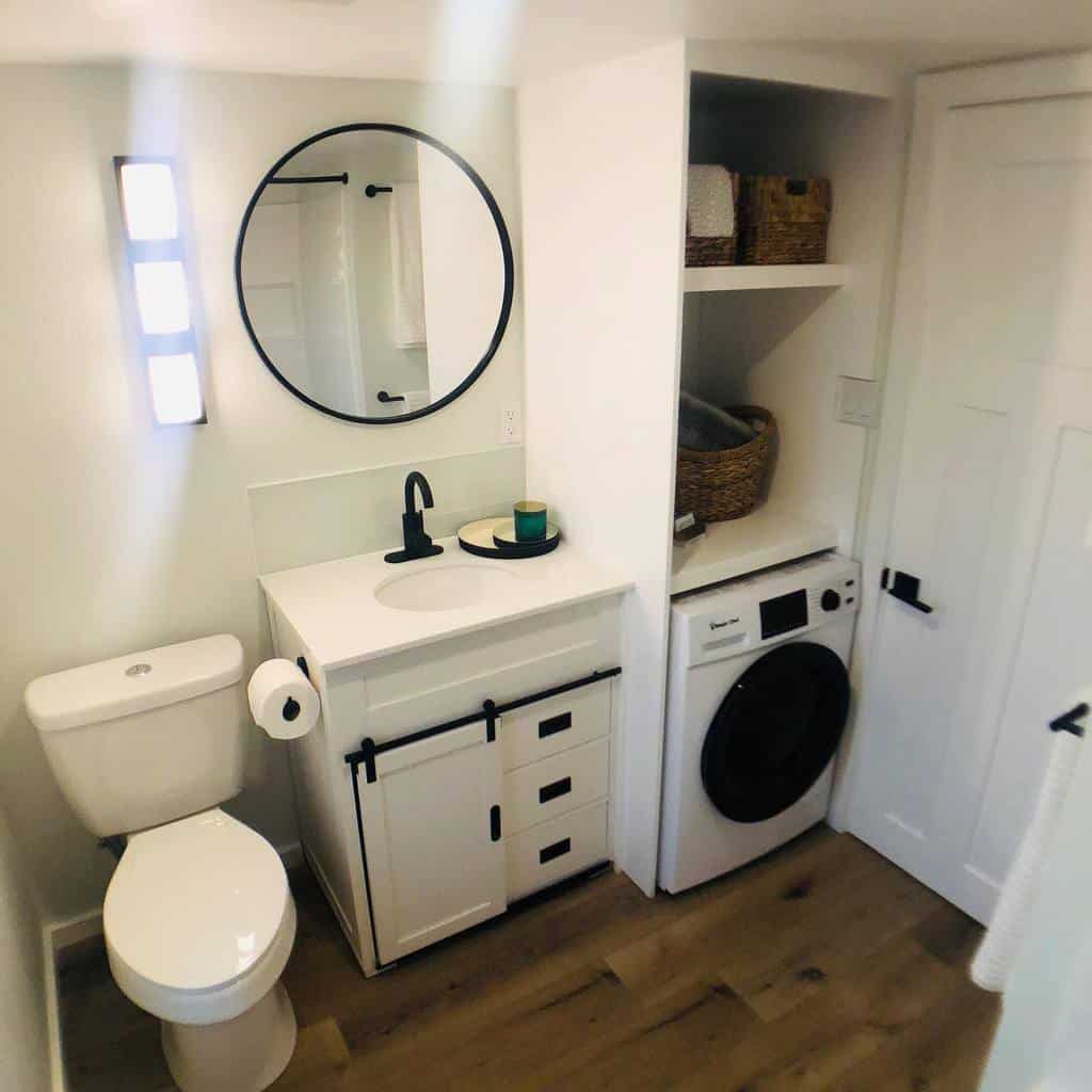 Compact bathroom featuring design ideas for small spaces with white vanity, round mirror, modern light, toilet, and compact washer.