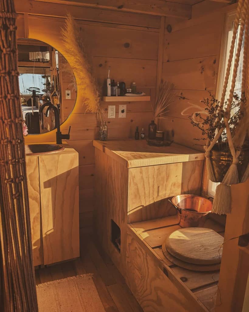 Cozy wooden room with rustic decor: a round mirror, pampas grass, and copper bowl; perfect small spaces design ideas with warm light.