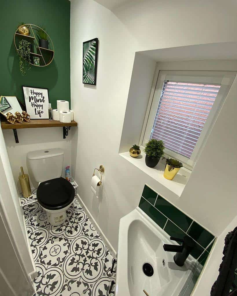 Charming small bathroom featuring green and white decor, patterned floor, wall art, plants, and small spaces design ideas.