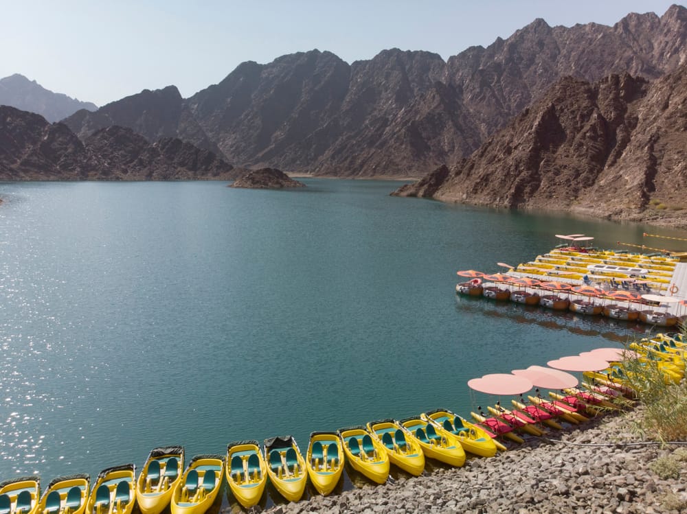 Row of yellow kayaks by mountain lake