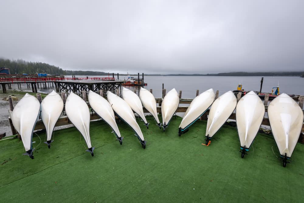 Inverted kayaks lined up side by side on a dock