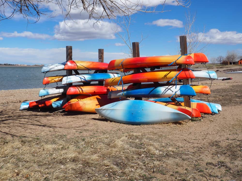 Colorful kayaks stacked lakeside