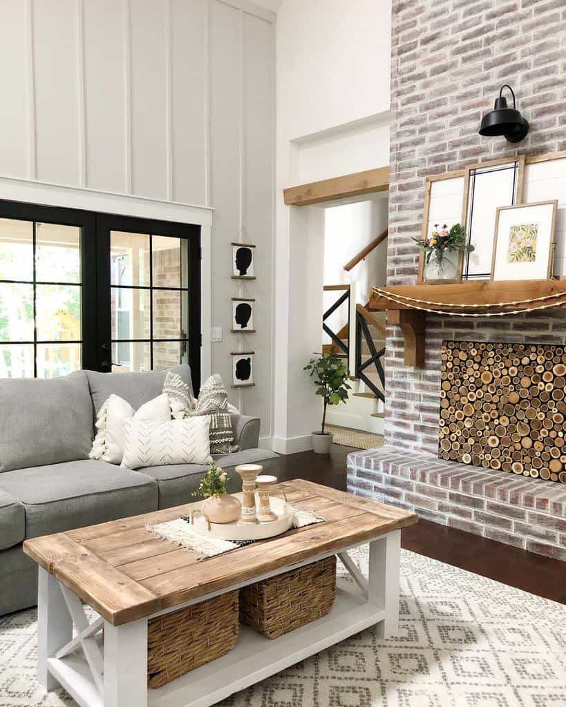 Rustic farmhouse coffee table with a wooden top and white base, featuring wicker baskets for storage and a tray with candles and decor