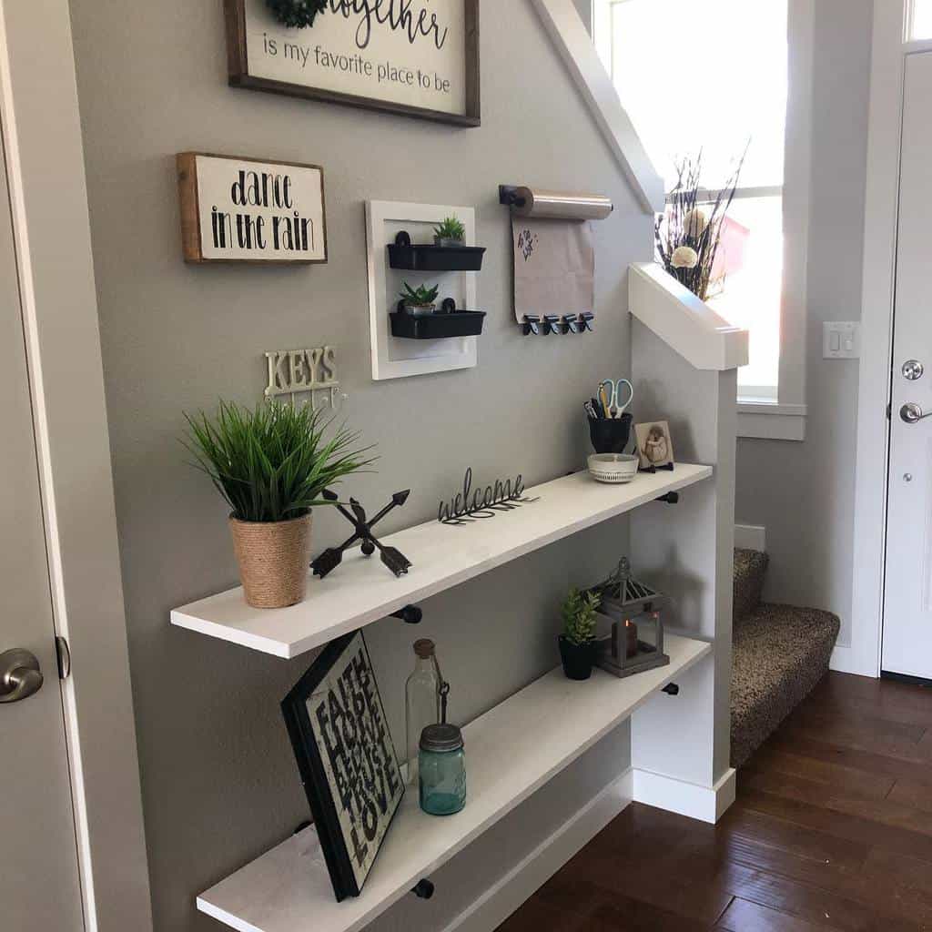 Stylish small entryway with white floating shelves, greenery, decorative signs, and functional storage for a cozy and organized look