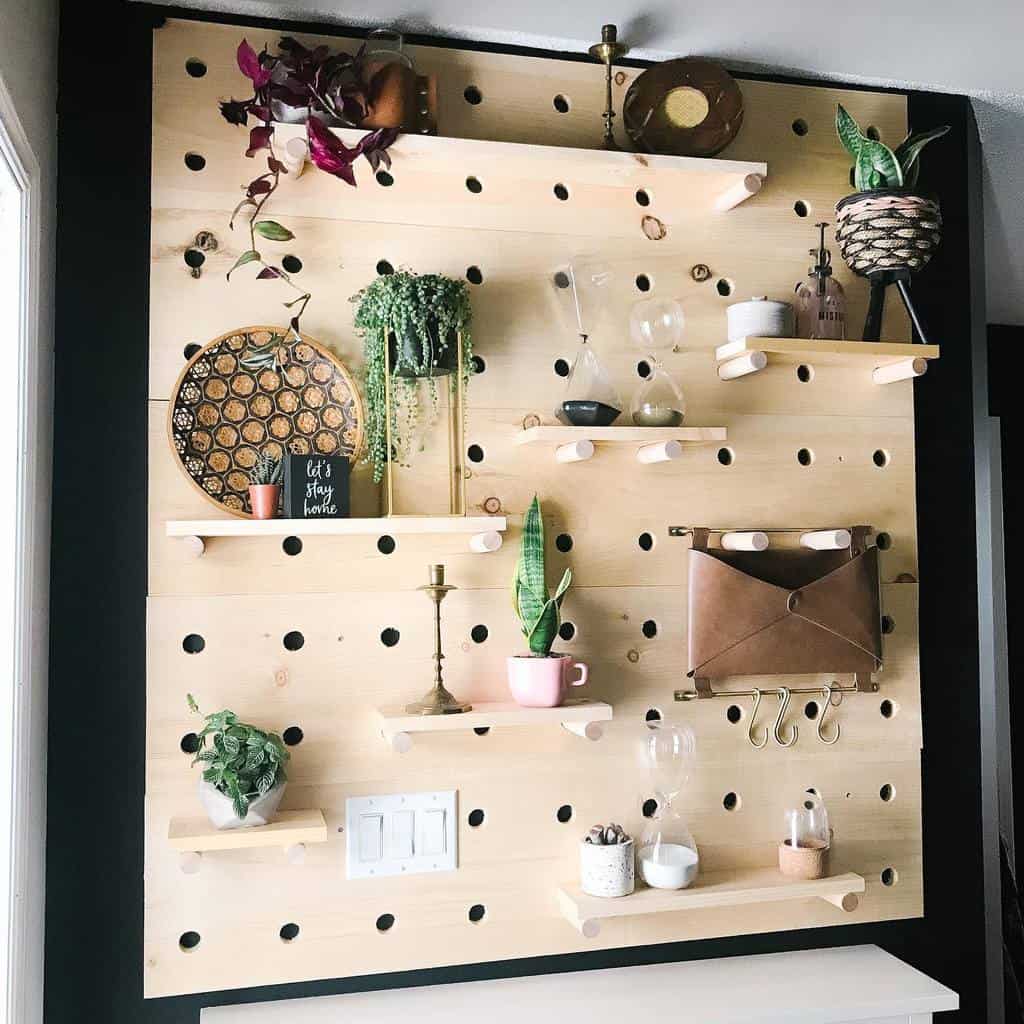 Modern entryway with a wooden pegboard wall, adjustable shelves, greenery, decorative accents, and a leather organizer for a stylish touch