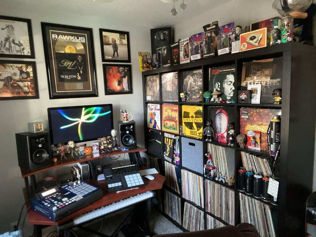 Hip-hop-inspired music room with vinyl records, framed album covers, a production setup, studio monitors, and collectible figurines