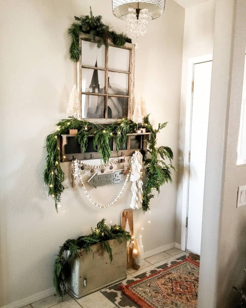 Rustic farmhouse entryway with festive greenery, vintage window decor, string lights, and a cozy holiday-inspired touch