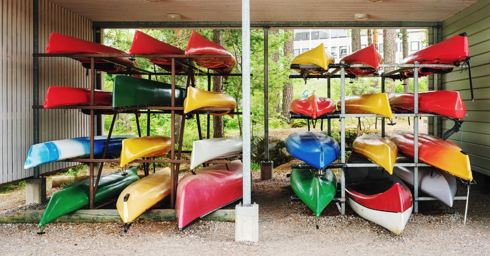 Modern kayaks stored on metal racks
