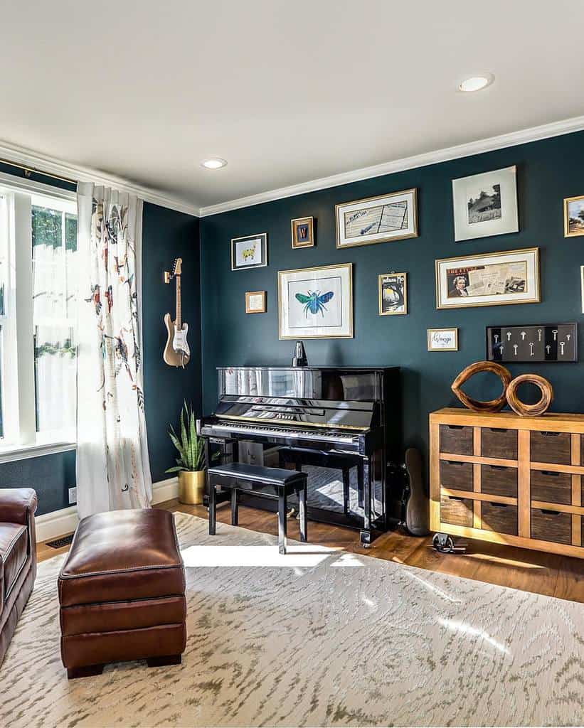 Stylish music room with a black upright piano, wall-mounted guitar, framed artwork, deep green walls, and warm leather seating