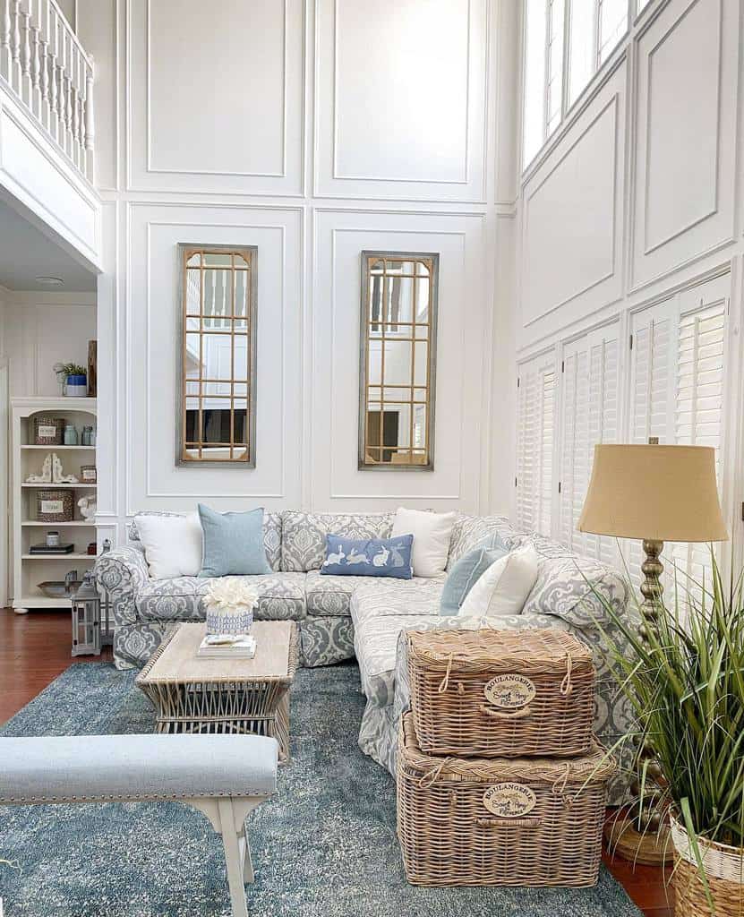 Coastal-style wicker coffee table with a wooden top, styled with books and flowers, set in a bright living room with blue and white decor