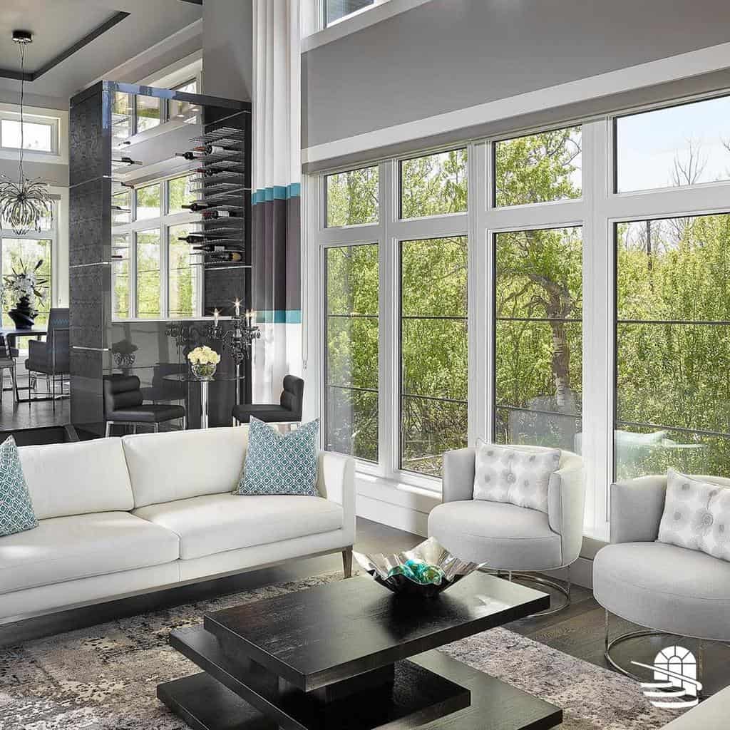 Modern black stacked coffee table with a sleek design, styled with a decorative bowl, set in a luxurious living room with large windows and white seating