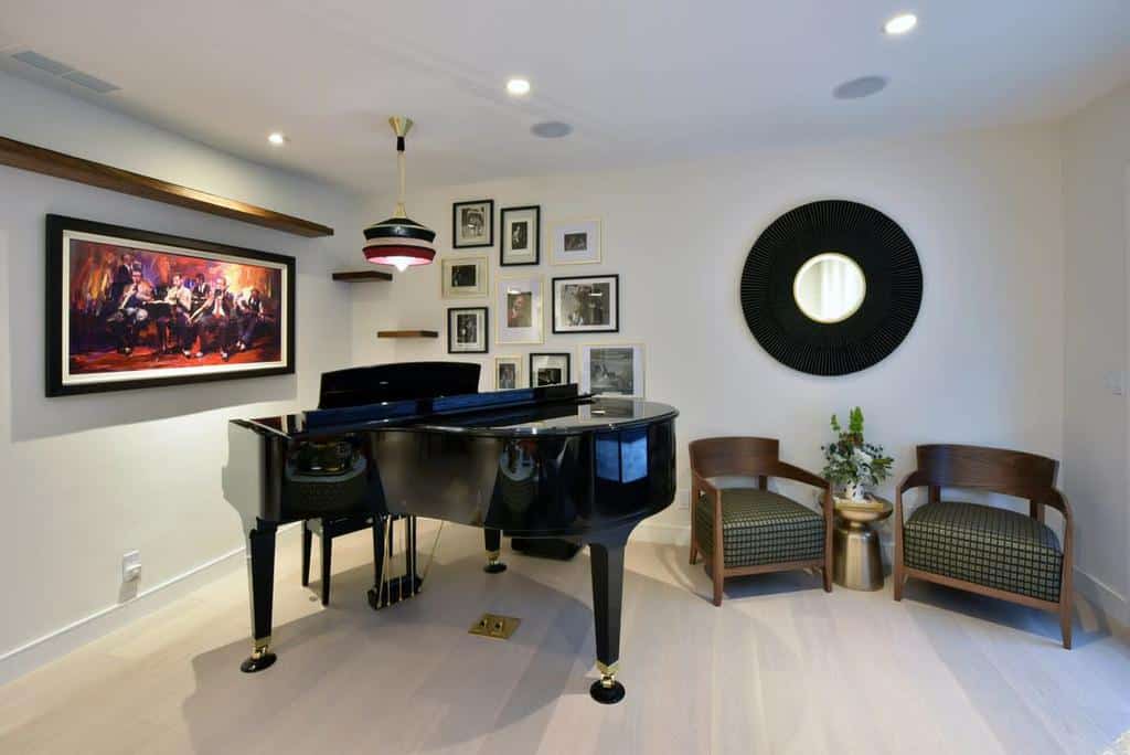 Sophisticated music room with a grand piano, framed artwork, stylish seating, a decorative mirror, and warm ambient lighting